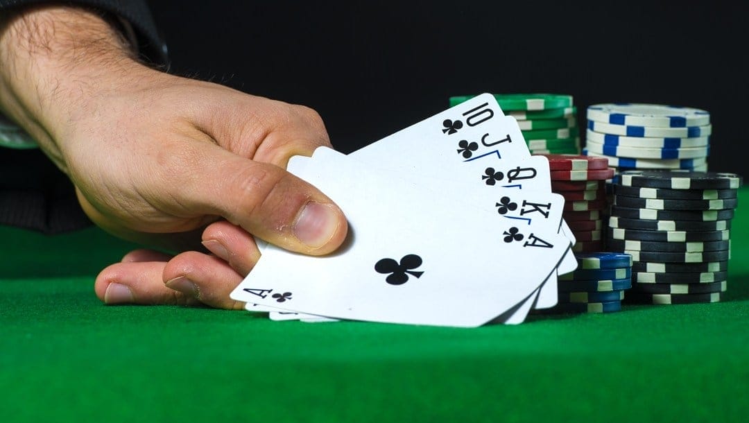 A poker player reveals a royal flush.