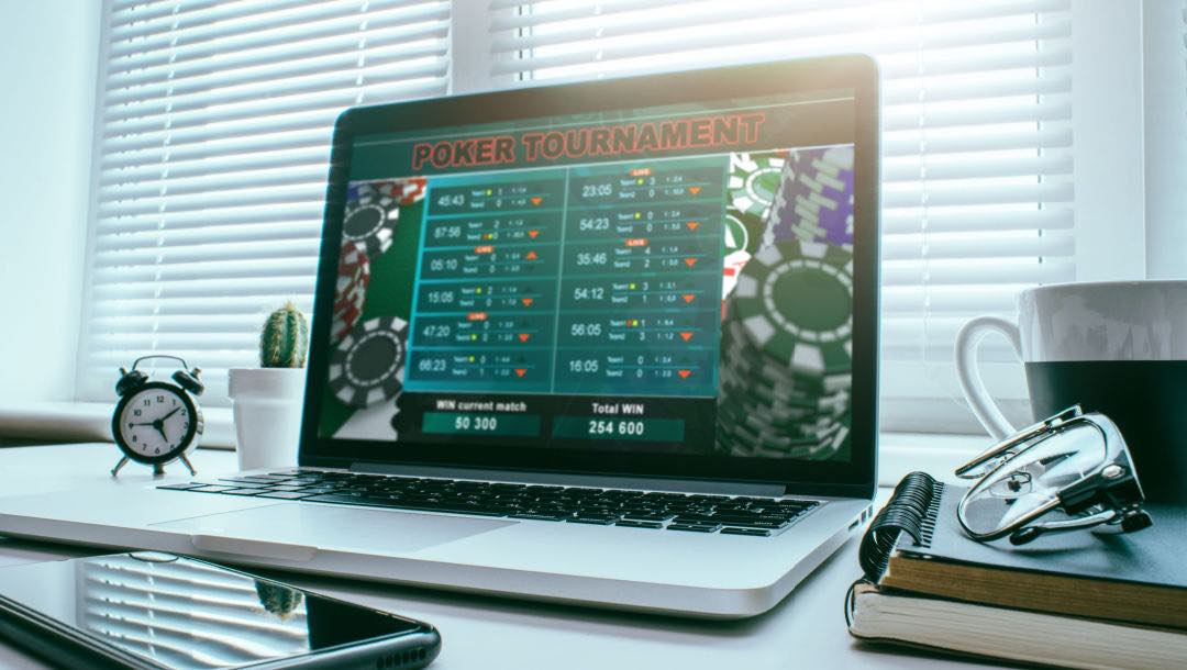 Laptop screen on a desk displaying a live poker tournament online.