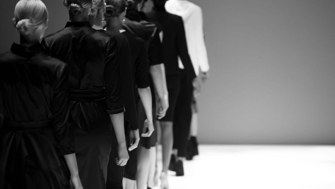 Fashion models on a runway in black and white.
