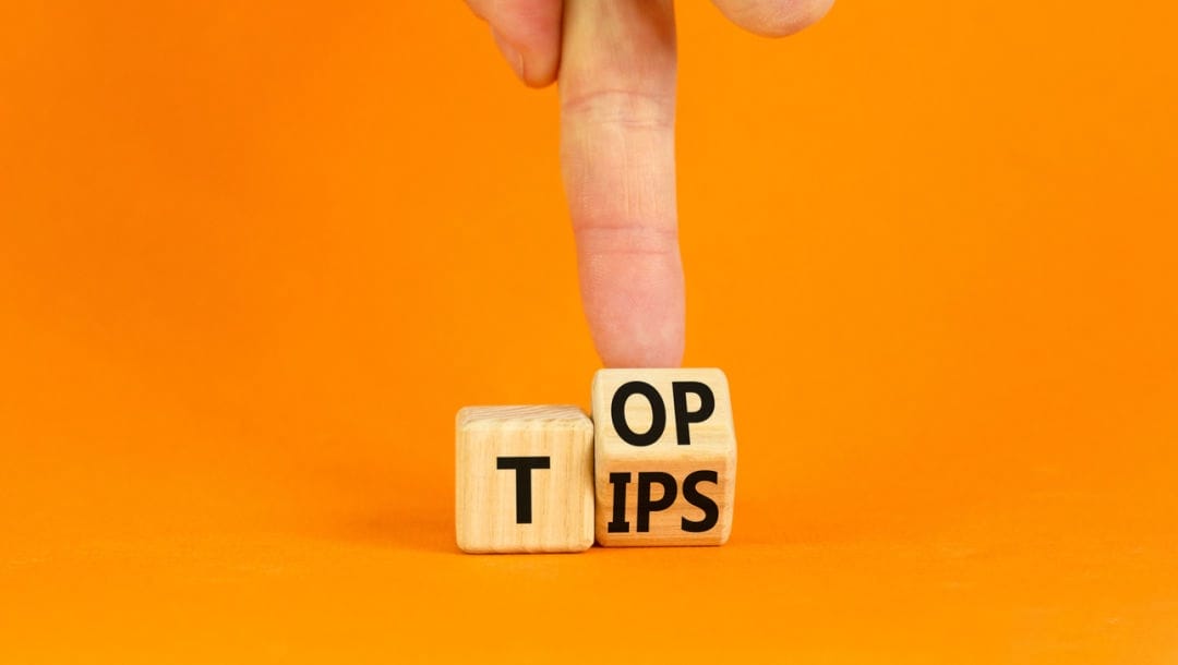 “Top tips” written on wooden blocks against an orange background.