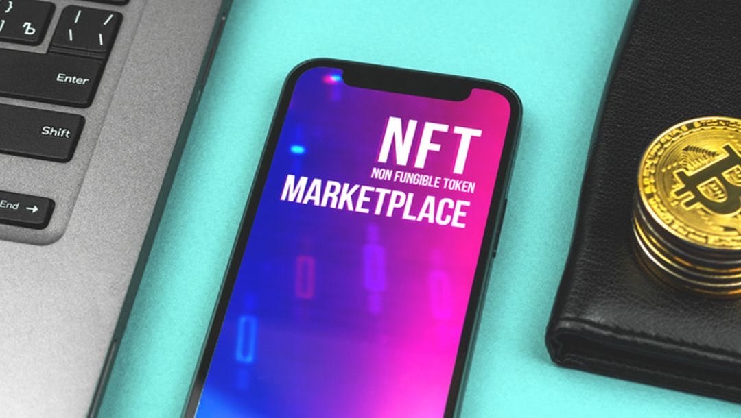 A laptop, gold coins, and a smartphone featuring “NFT Marketplace.”