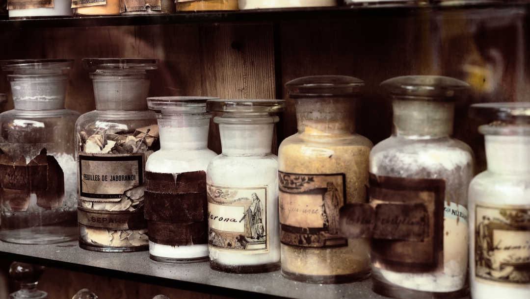 A shelf filled with old jars of medicines