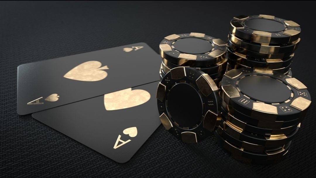 Black and gold casino chips and playing cards.