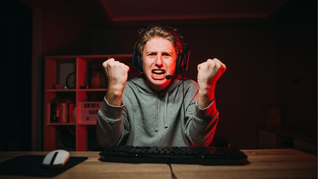 an angry gamer displaying emotions of distress and anguish at his computer screen