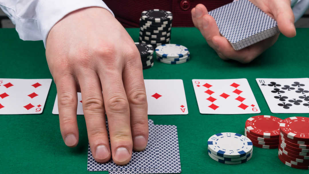 Close up of a dealer putting down cards on a poker table