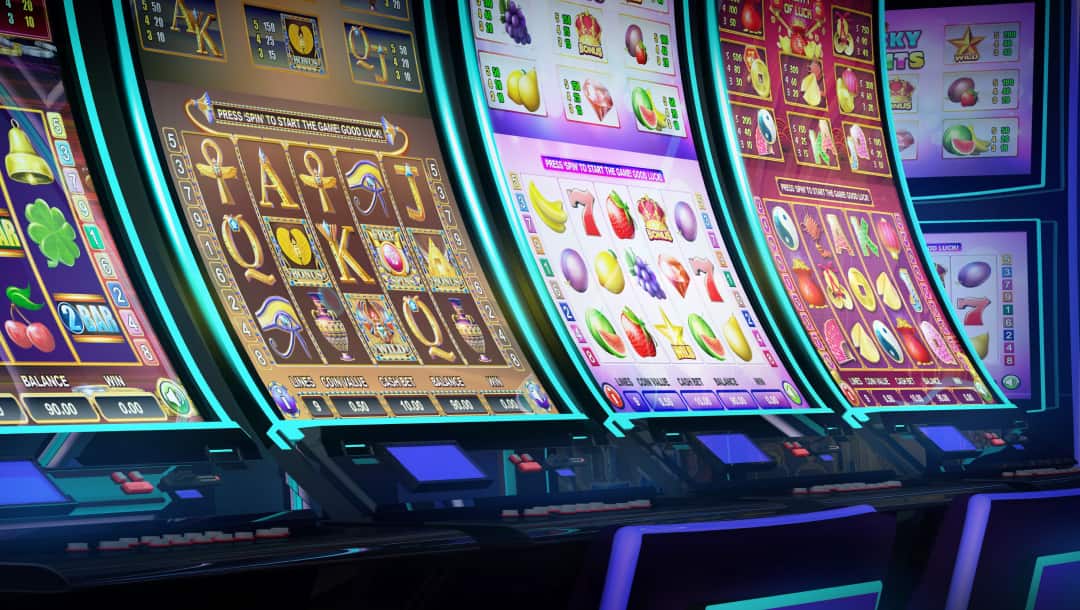 A row of four slot machines with various themes lined up on a casino floor.