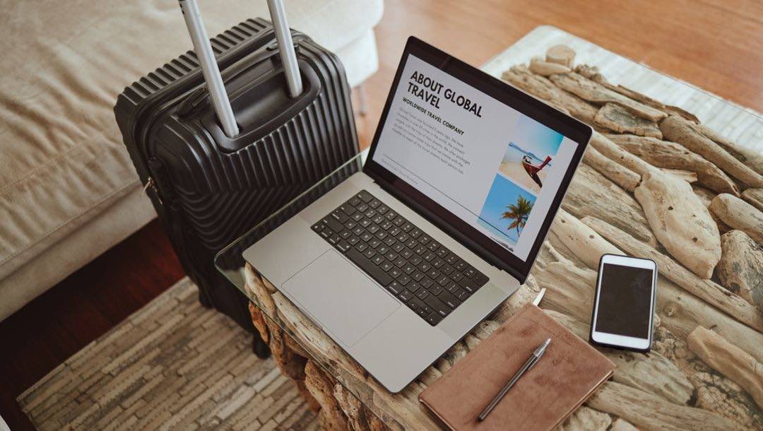 The laptop, smartphone and suitcase of a luxury traveler.