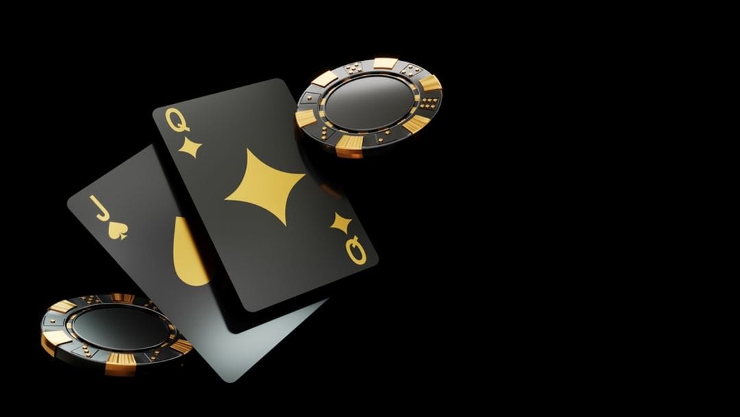Black and gold casino chips and playing cards.