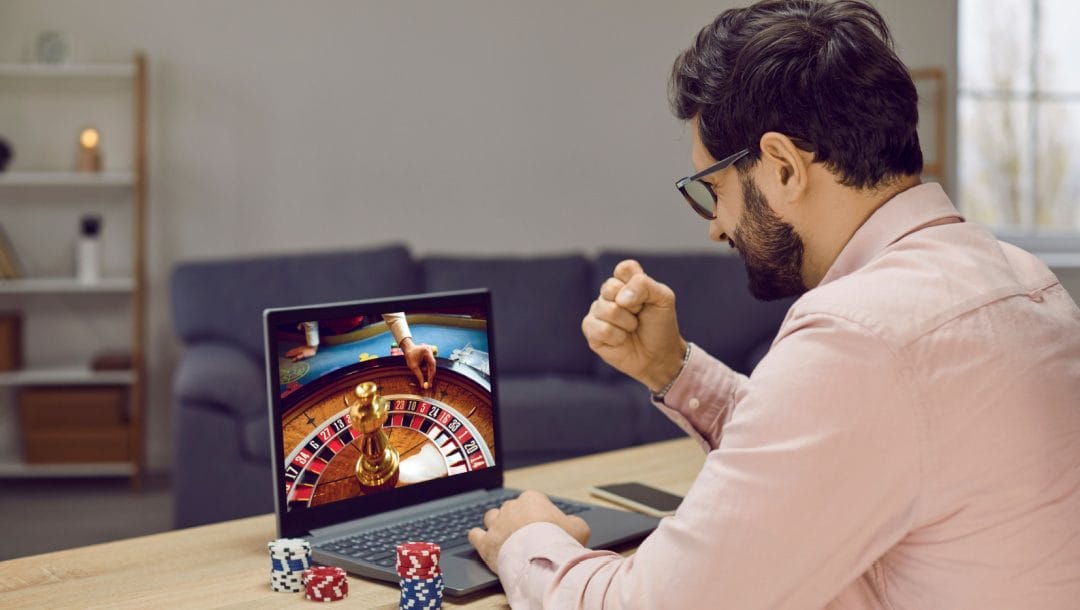 A man plays roulette on a laptop in his home