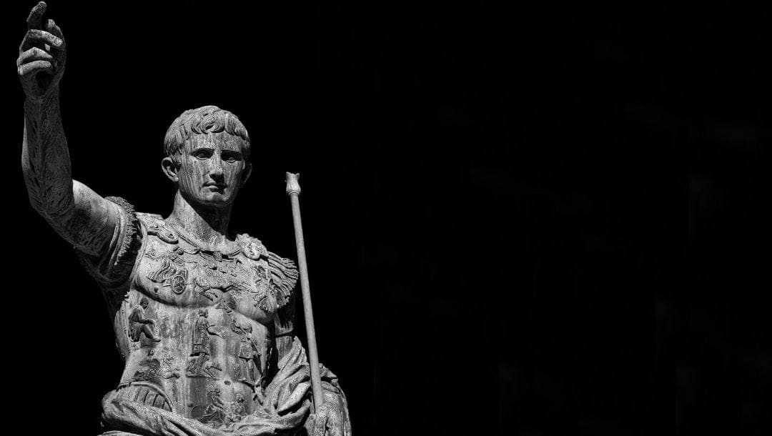 a statue of Ancient Rome leader, Julius Caesar, against a black background