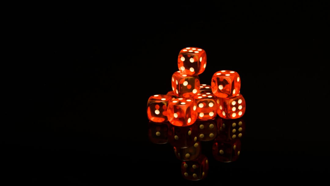 Red dice against a black background.