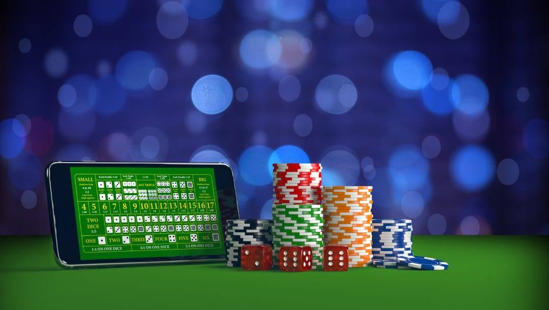 Online casino gambling on a smartphone with dice and casino chips.