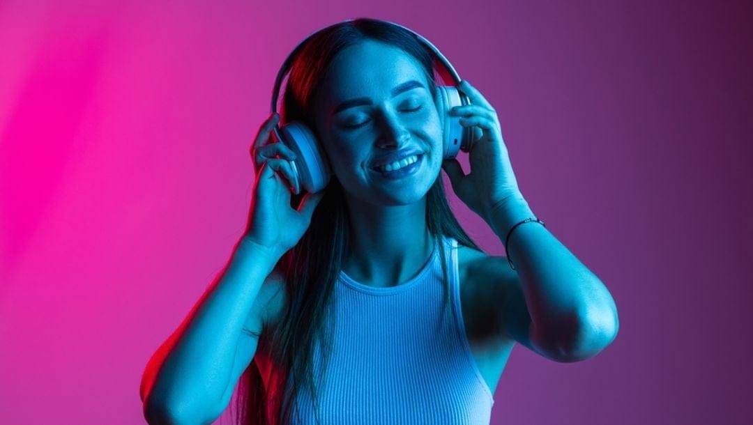 A woman listening to music through headphones.