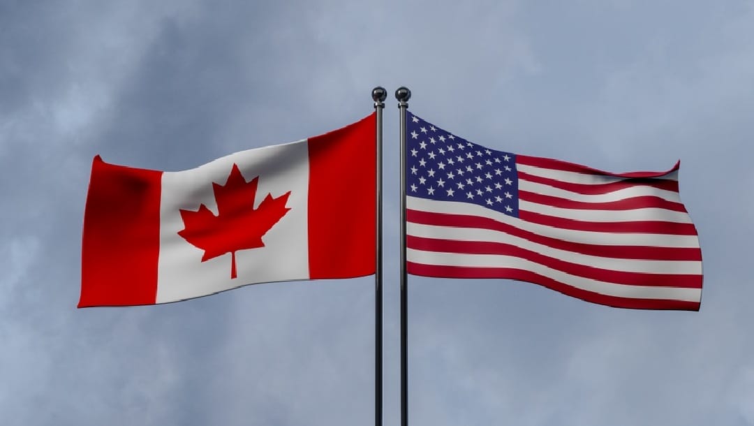 A Canadian and American flag next to each other.