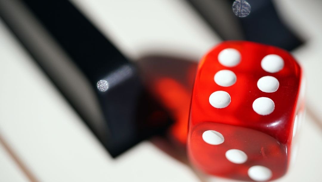 a close up of a red six-sided dice on a piano