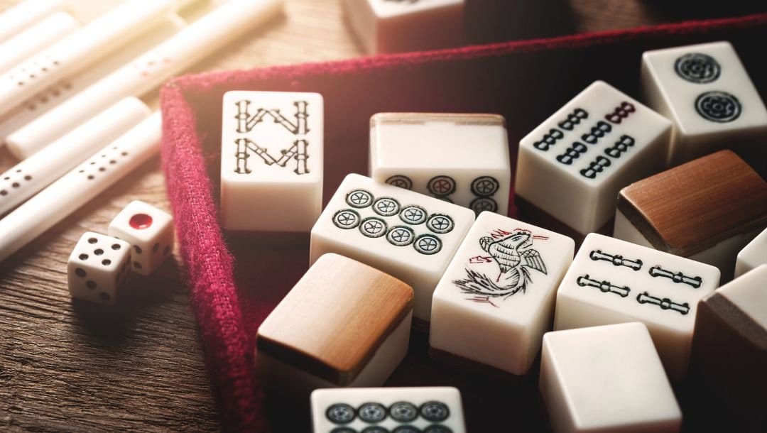 A box filled with Mahjong tiles placed on a table.