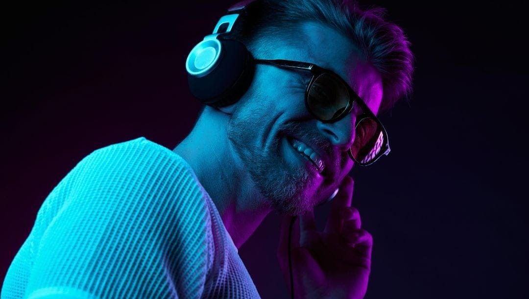 a man smiling while wearing headphones and listening to music
