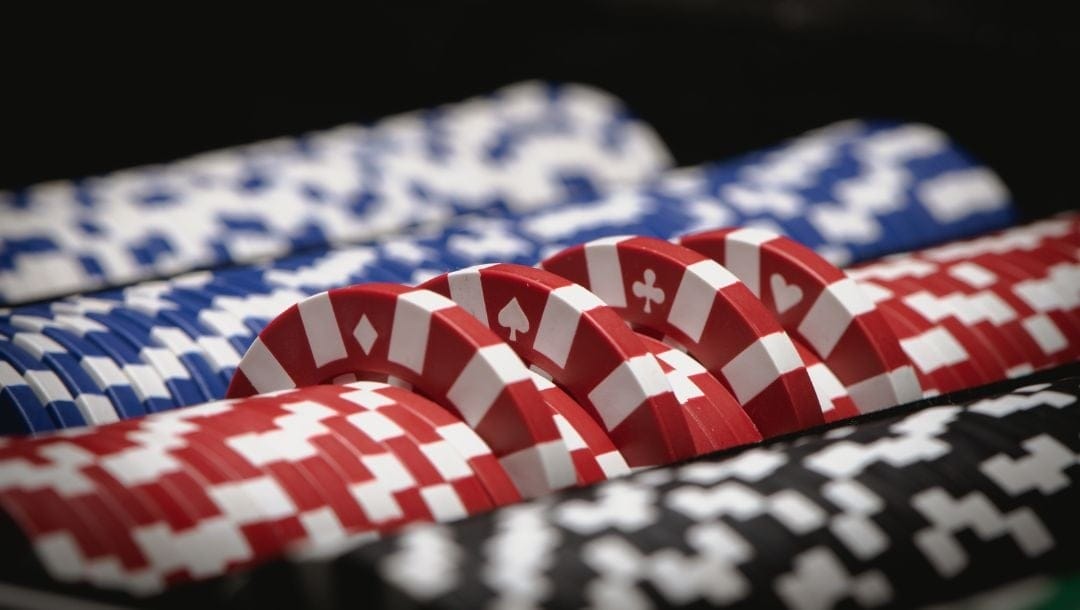 close up of poker chips stacked together in a set with a couple red ones sticking out the top
