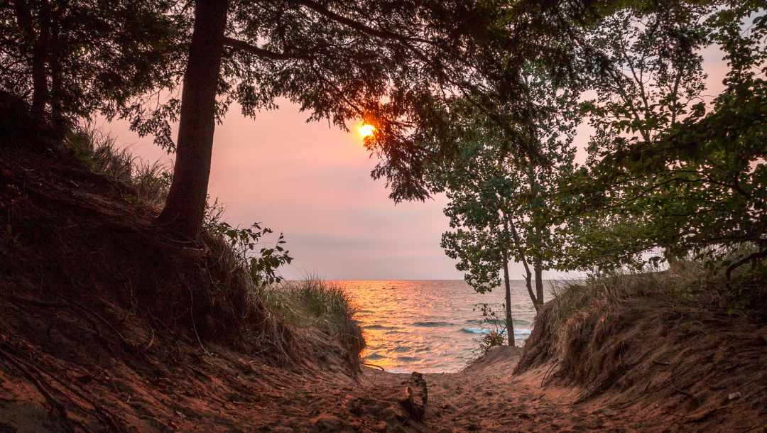 the sun setting on Lake Michigan in Saugatuck, Michigan