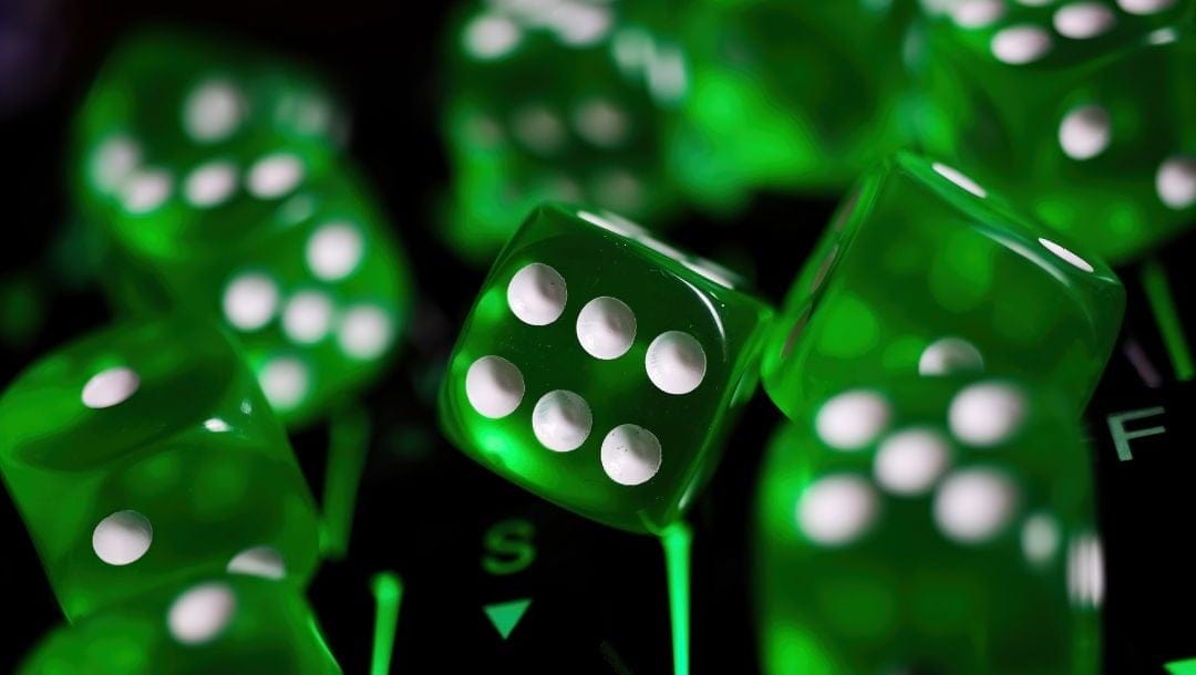 close up of multiple green six-sided dice on a computer keyboard