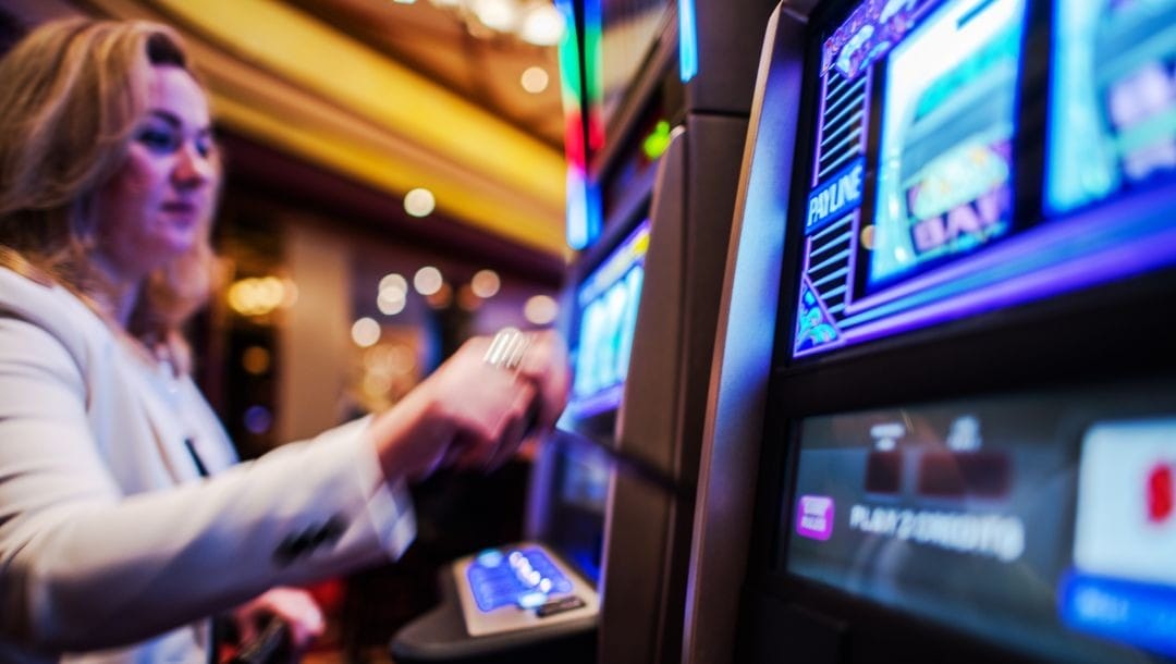 a woman swiping her card on a slot machine in a casino