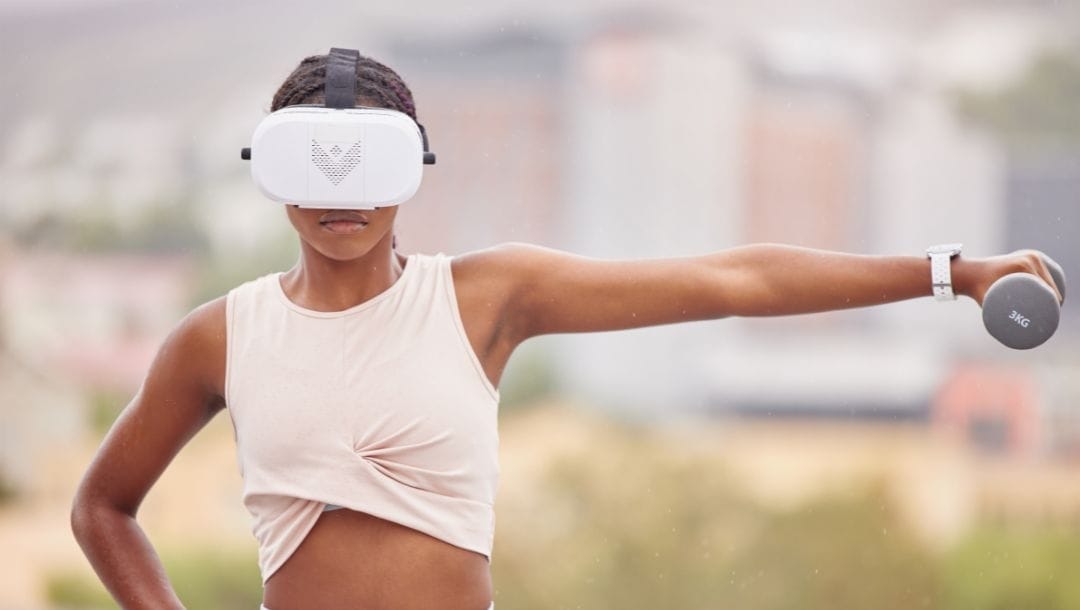 a woman wearing a VR headset and lifting a weight to her side