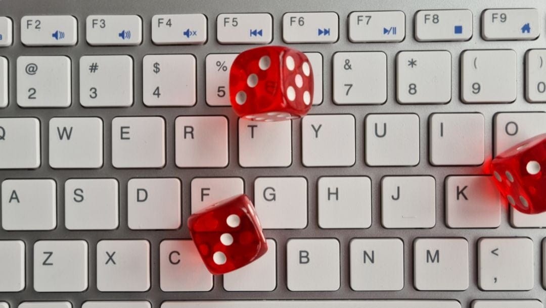 top view of three red six-sided dice on a computer keyboard