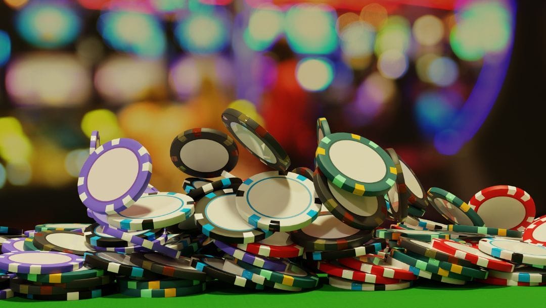 An extreme closeup photograph of poker chips falling onto a green table.