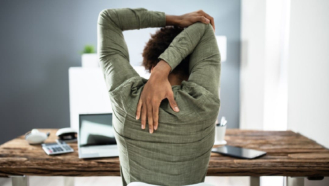 A person stretching at their desk