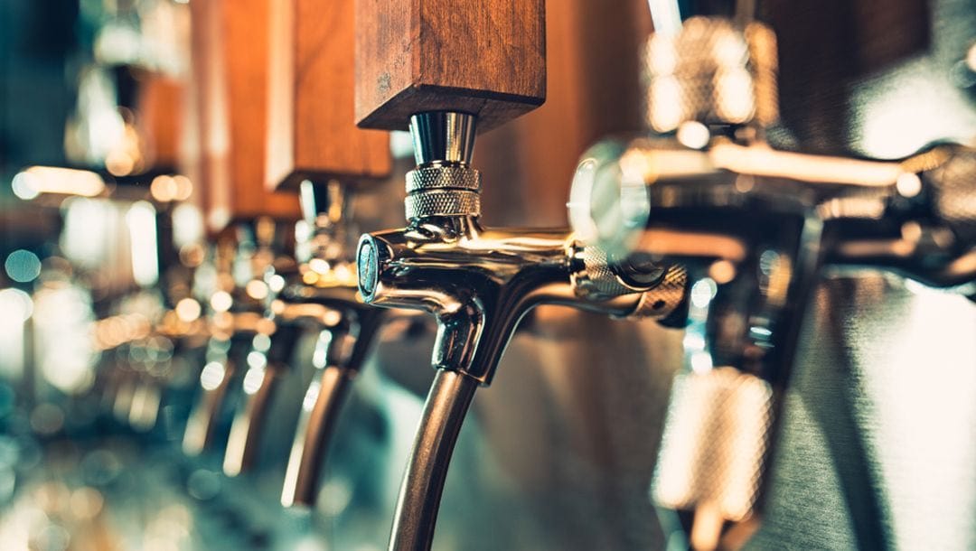 Closeup of a row of beer taps at a brewery.