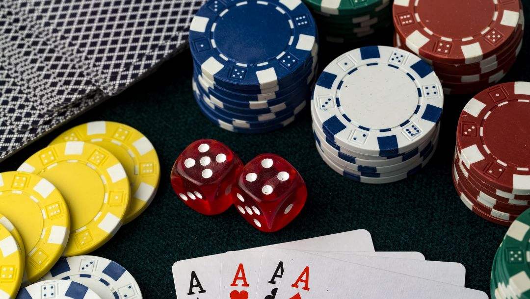 Playing cards, casino chips, and two red dice arranged on a table.