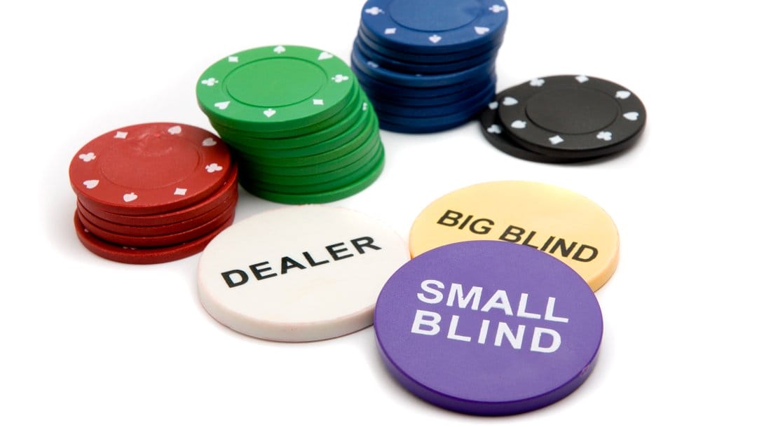 The three poker buttons for the dealer, big blind, and small blind, next to several stacks of poker chips.