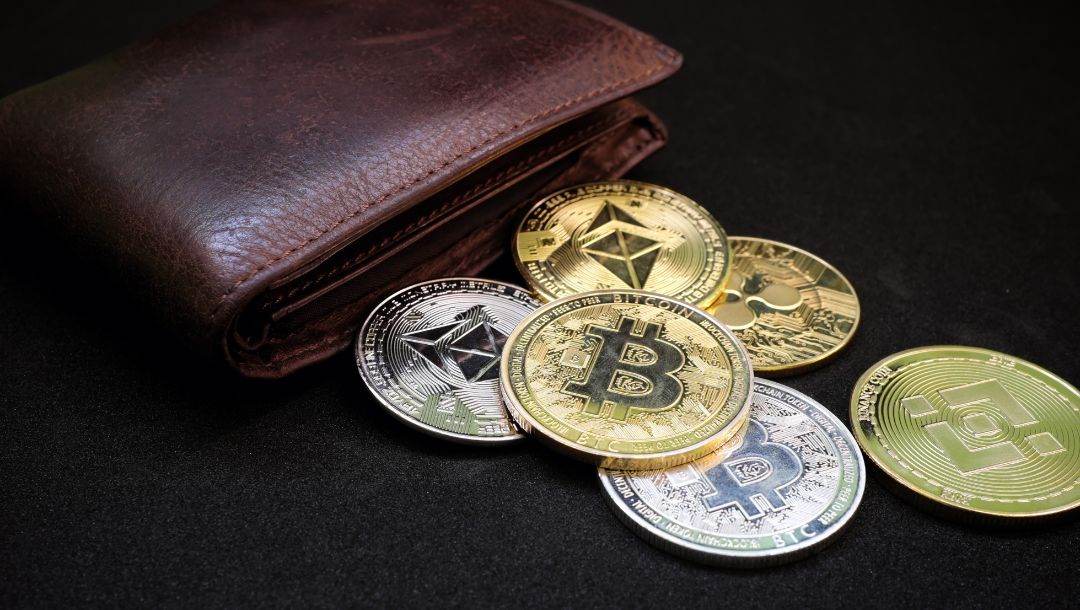 cryptocurrency coins coming out of a brown leather wallet