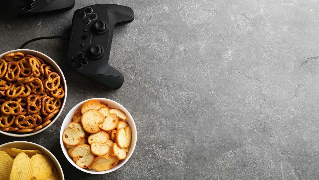 bowls of snacks neck to two gaming controls
