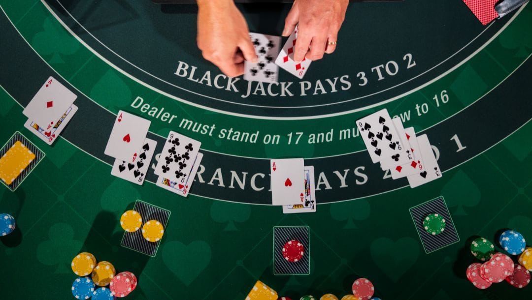 A top-down photograph of a blackjack dealer dealing cards at a full blackjack table.