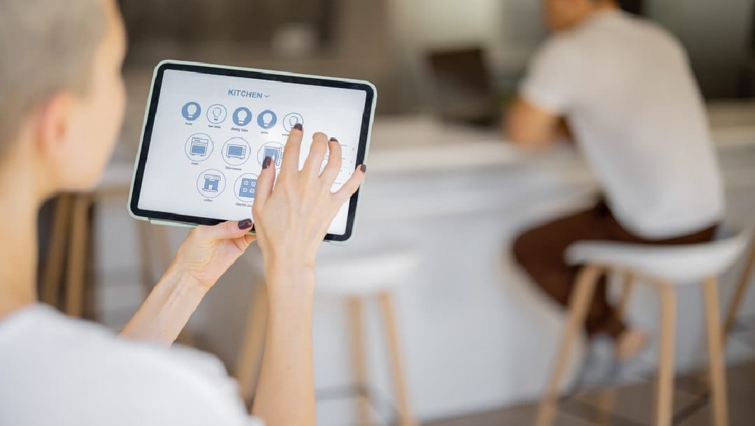 A person controls their smart home devices on a tablet.