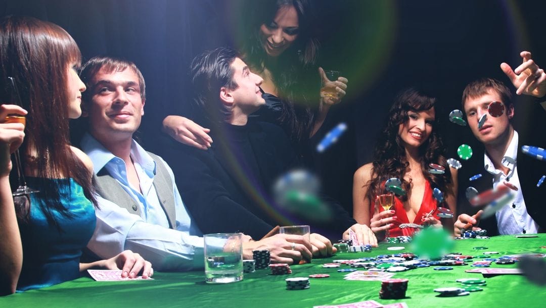 A group people surround a poker table, enjoying themselves