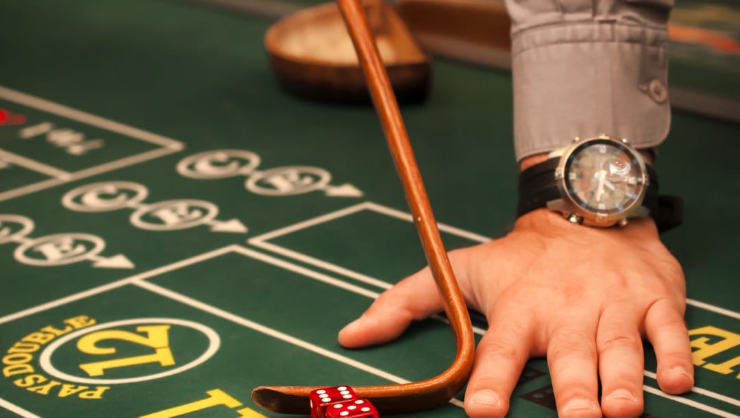 Craps table with a dealer’s hand and dice.