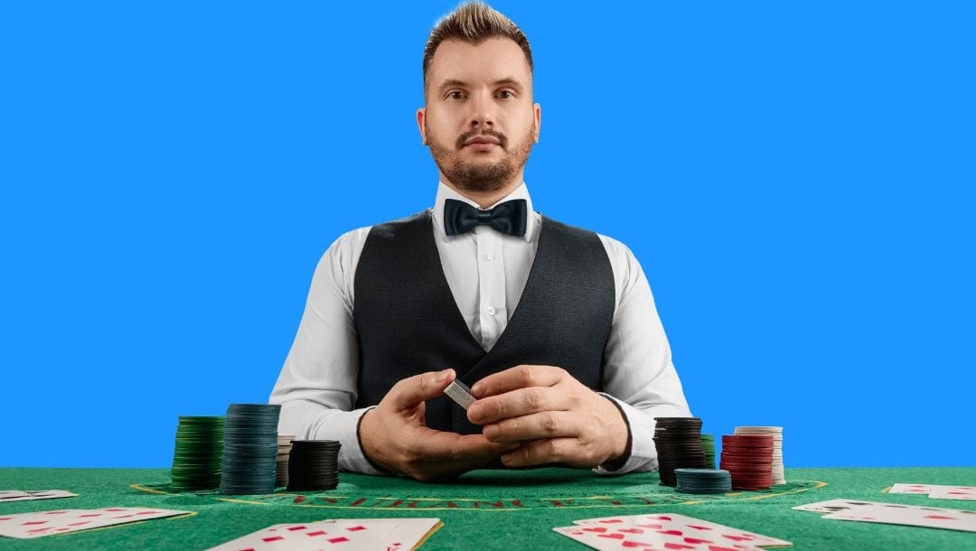 a dealer sitting at a blackjack table with playing cards and poker chips on it with a bright blue background