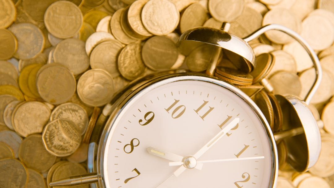 Beautiful old clock on a background of golden coins.