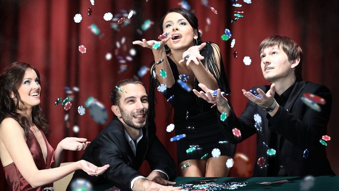 Young people throwing poker chips in the air at a casino