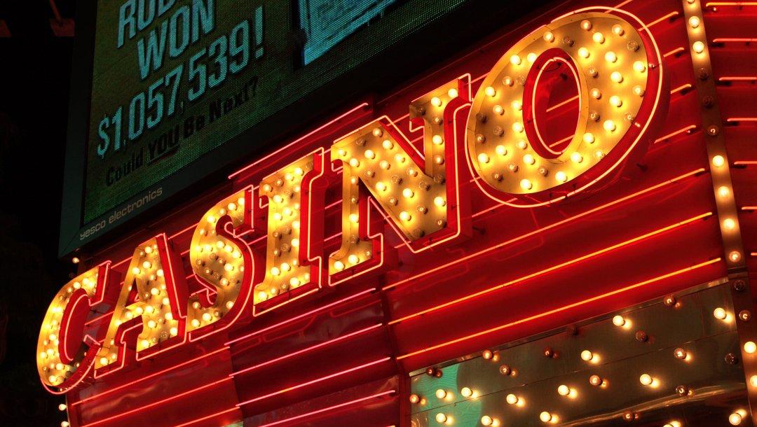 A bright red and yellow casino sign surrounded by lights.