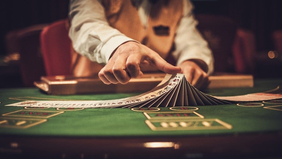 A croupier shuffles cards on a casino table