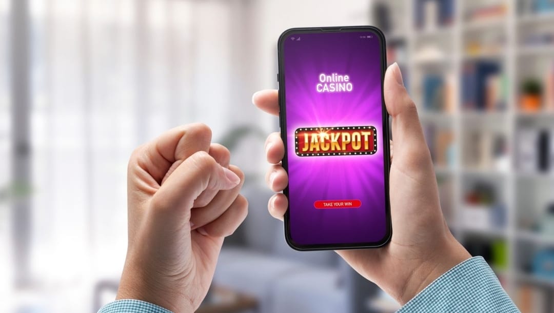 A fist clenched in celebration next to a phone that says jackpot on the screen