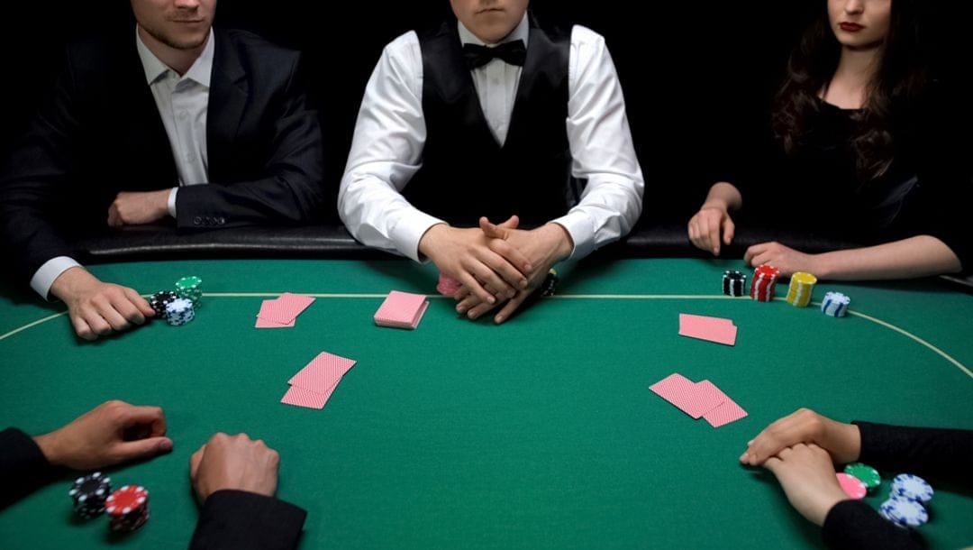 A group of well-dressed people sitting around a poker table.