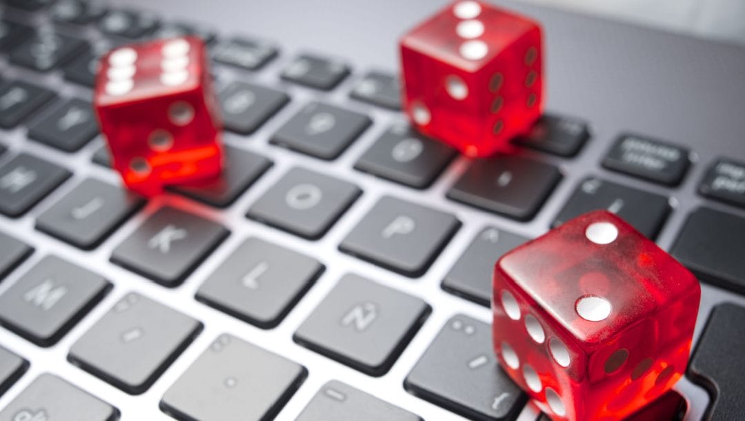Three red dice on a keyboard.