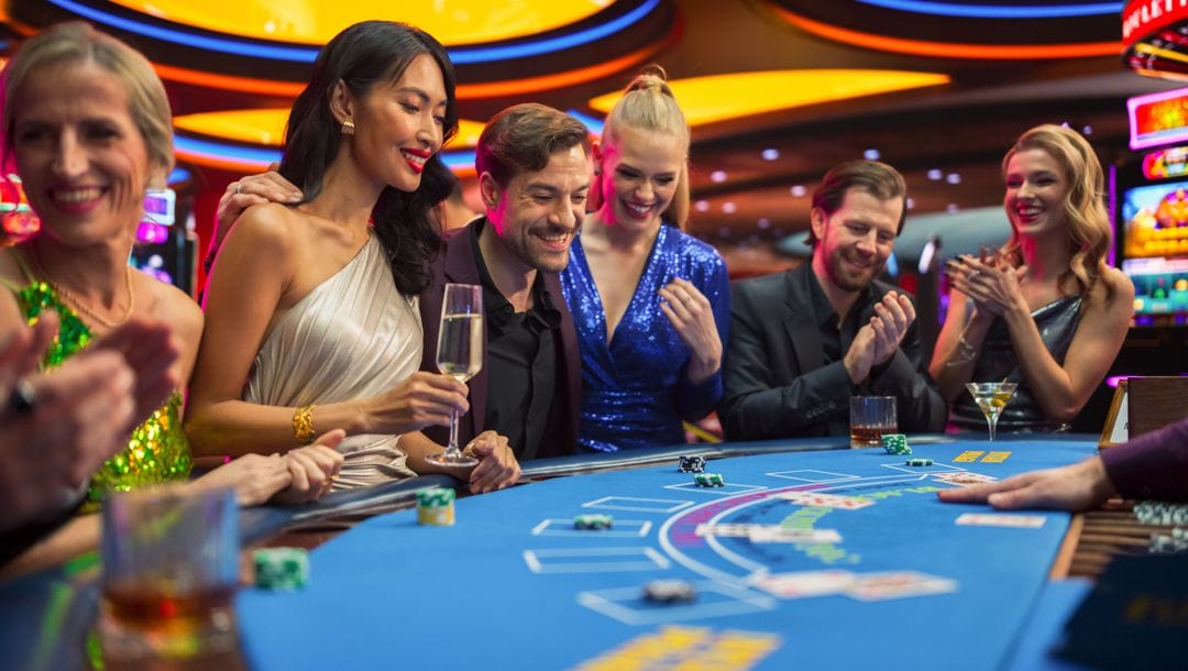A group of people smiling while playing a casino table game.
