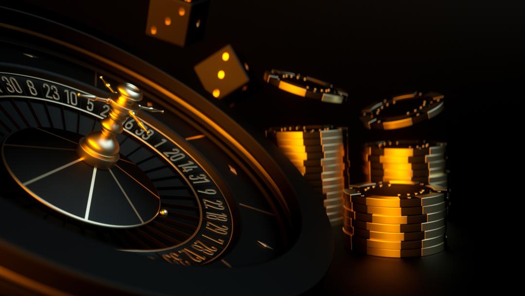 A 3D-rendered roulette wheel next to stacks of casino chips with a pair of dice falling in the background. All the items are black and gold and placed against a black background.