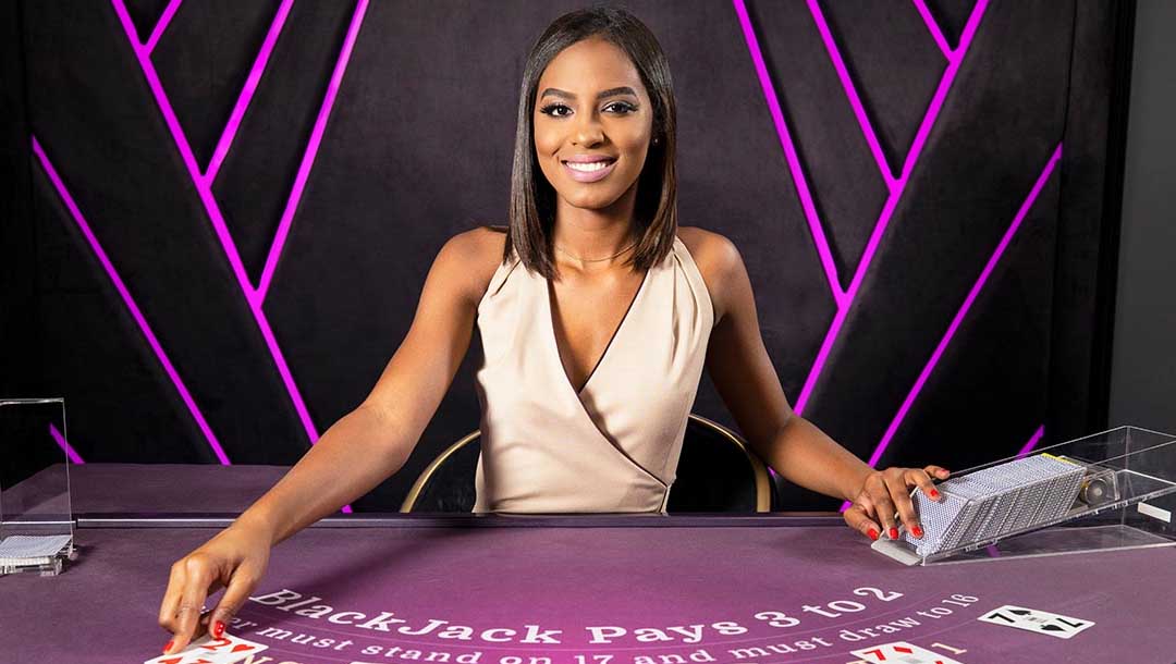 A woman sitting at a purple blackjack table, dealing cards out.