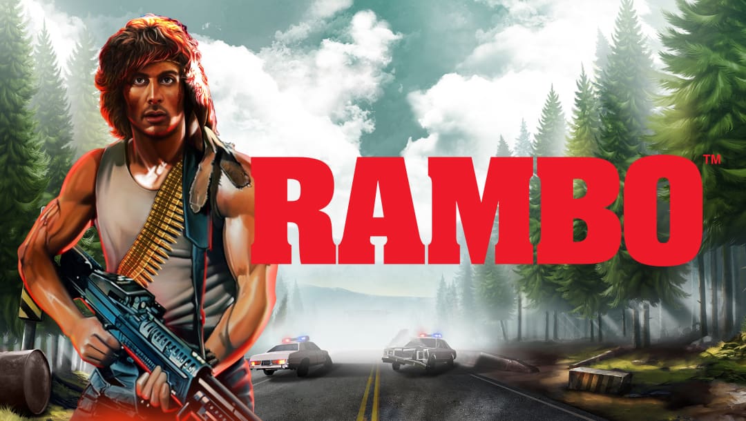 The Rambo online slot loading screen featuring the game and movie title, Rambo, and a scene in the background featuring a road in between a forest and two cop cars in the road.